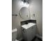 Stylish powder room with a gray vanity, round mirror, and modern fixtures at 1809 S H St, Elwood, IN 46036