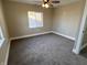 Bedroom with gray carpet, white trim, ceiling fan, and a window providing natural light at 1809 S H St, Elwood, IN 46036