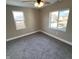 Bedroom with gray carpet, white trim, ceiling fan, and two windows providing natural light at 1809 S H St, Elwood, IN 46036