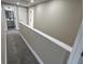 Carpeted hallway with white trim and doorways that lead to a bathroom and bedrooms at 1809 S H St, Elwood, IN 46036