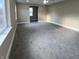 Living room with gray carpet, three windows and a ceiling fan at 1809 S H St, Elwood, IN 46036