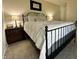 Cozy bedroom featuring a metal bed frame, bedside tables with lamps, and neutral walls at 1862 Cascades Dr, Greenfield, IN 46140