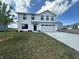 Charming two-story home with a lush green lawn and a freshly poured concrete driveway at 1862 Cascades Dr, Greenfield, IN 46140