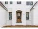 Close up view of the front door and entryway of a new home with painted white brick and contrasting wood door at 19909 Windsor Park Blvd, Westfield, IN 46069