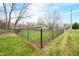 Backyard with a chain-link fence, green lawn, and mature trees, offering a serene outdoor space at 2072 S Rembrandt Cv, Martinsville, IN 46151