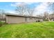 View of backyard featuring lawn, mature trees, and exterior of the home in a suburban neighborhood at 2072 S Rembrandt Cv, Martinsville, IN 46151