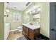 Bathroom with dark wood vanity, toilet, and a view of washer and dryer in a room with a window at 2072 S Rembrandt Cv, Martinsville, IN 46151
