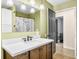 A bathroom featuring a wood vanity, mirror, and doorway leading to a grey-walled room with a pet crate at 2072 S Rembrandt Cv, Martinsville, IN 46151
