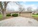 View of the home with a two-car garage and gravel driveway, set on a spacious lot at 2072 S Rembrandt Cv, Martinsville, IN 46151