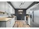Modern kitchen with white cabinets, stainless steel appliances, light countertops, and wood-look floors at 2072 S Rembrandt Cv, Martinsville, IN 46151