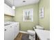 Laundry room with a white washer and dryer set, toilet, and a window, creating a functional space at 2072 S Rembrandt Cv, Martinsville, IN 46151