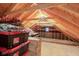Unfinished attic space offers potential with exposed beams and ample storage, illuminated by a single light at 222 Wellington Pkwy, Noblesville, IN 46060