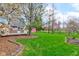 Expansive backyard with lush lawn, mature trees, landscaping, and a view of the deck at 222 Wellington Pkwy, Noblesville, IN 46060