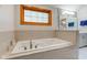 Relaxing bathroom featuring a soaking tub with tile surround and a bright window for natural light at 222 Wellington Pkwy, Noblesville, IN 46060