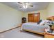 This light yellow bedroom features wooden trim, neutral carpet, and a ceiling fan at 222 Wellington Pkwy, Noblesville, IN 46060