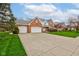 Classic brick home with an attached three-car garage and a long driveway, all on a well-kept lawn at 222 Wellington Pkwy, Noblesville, IN 46060