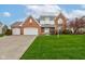 Charming two-story brick home featuring an attached three-car garage and a lush green lawn at 222 Wellington Pkwy, Noblesville, IN 46060