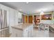 Open-concept kitchen with granite island, white cabinets, and seamless flow into the dining area at 222 Wellington Pkwy, Noblesville, IN 46060