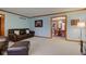 Spacious living room with a comfortable leather couch and an open view to the dining area at 222 Wellington Pkwy, Noblesville, IN 46060