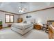 Cozy main bedroom features a tray ceiling, ceiling fan, carpet, and ample natural light from the large window at 222 Wellington Pkwy, Noblesville, IN 46060