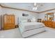 Beautifully appointed main bedroom features a tray ceiling, ceiling fan, carpet, and warm wood furnishings at 222 Wellington Pkwy, Noblesville, IN 46060
