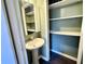 This bathroom features a pedestal sink and a built-in storage cabinet with shelves at 2253 Chandler Ln, Columbus, IN 47203