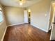 Bright bedroom with hardwood floors, a window, and a glimpse of a bathroom through an open door at 2253 Chandler Ln, Columbus, IN 47203