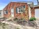 Brick house with green shutters and blossoming yellow bushes framing the entrance at 2253 Chandler Ln, Columbus, IN 47203