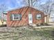 Cozy brick home with green shutters and budding flowers in the front yard, under a clear sky at 2253 Chandler Ln, Columbus, IN 47203