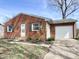 Charming brick home with a white garage door, green shutters, and budding yellow bushes at 2253 Chandler Ln, Columbus, IN 47203