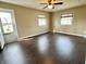 Bright, spacious living room featuring hardwood floors, a ceiling fan, and two windows at 2253 Chandler Ln, Columbus, IN 47203