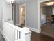 Hallway features wood floors, a white railing, and leads to a bathroom and another room at 234 S State Ave, Indianapolis, IN 46201