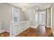 Bright hallway features hardwood floors, a white railing, and a modern light fixture at 234 S State Ave, Indianapolis, IN 46201