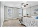 Comfortable bedroom has carpet, a ceiling fan, and a tray with a floral arrangement on bed at 234 S State Ave, Indianapolis, IN 46201