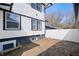 Side yard with white siding, privacy fence and exposed dirt and a window to the basement at 2920 E 11Th St, Indianapolis, IN 46201