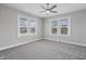 Bright bedroom featuring neutral carpet, a ceiling fan, and large windows with neighborhood views at 2920 E 11Th St, Indianapolis, IN 46201