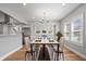 Sunlit dining room featuring hardwood floors, modern chandelier, and a view into the kitchen area at 2920 E 11Th St, Indianapolis, IN 46201