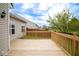 Back deck with light wood and light siding overlooking the green yard and brown wood fence at 3168 Lodgepole Dr, Whiteland, IN 46184