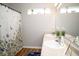 Bright bathroom with a floral shower curtain, dual sinks, and neutral finishes at 3168 Lodgepole Dr, Whiteland, IN 46184