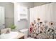Bathroom featuring a sink with cabinet, floral shower curtain, mirrored wall, and storage cabinet at 3168 Lodgepole Dr, Whiteland, IN 46184