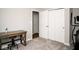 Carpeted bedroom featuring a closet with white doors, a desk, and a stationary exercise bike at 3168 Lodgepole Dr, Whiteland, IN 46184