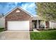 Charming brick home featuring an attached garage, well-manicured lawn, and welcoming front porch at 3168 Lodgepole Dr, Whiteland, IN 46184