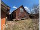 Two-story brick home with a gable roof and overgrown vegetation surrounding the property at 326 N Grant St, Brownsburg, IN 46112