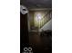 Dimly lit hallway with a staircase, a door, and various discarded items at 326 N Grant St, Brownsburg, IN 46112