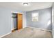A serene bedroom featuring plush carpeting, a window with blinds, and a closet with sliding wooden doors at 333 E Waterbury Rd, Indianapolis, IN 46227