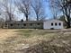 Backyard view of a home with stone and white siding, multiple windows, and bare trees at 3516 Circle Blvd, Indianapolis, IN 46220