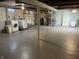 Unfinished basement area with painted floors and open ceiling featuring laundry hookup and utilities at 3516 Circle Blvd, Indianapolis, IN 46220