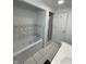Bathroom featuring a soaking tub with tiled surround and a glass-enclosed shower, plus tiled floors and a door at 3516 Circle Blvd, Indianapolis, IN 46220
