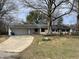 Inviting home exterior with concrete driveway, attached garage, and mature shade trees at 3516 Circle Blvd, Indianapolis, IN 46220