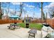 Private backyard featuring a patio with seating, a picnic table, and a manicured lawn at 3535 Birchwood Ave, Indianapolis, IN 46205